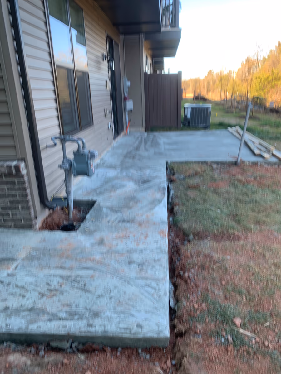 New poured concrete walkway running along the side of a house